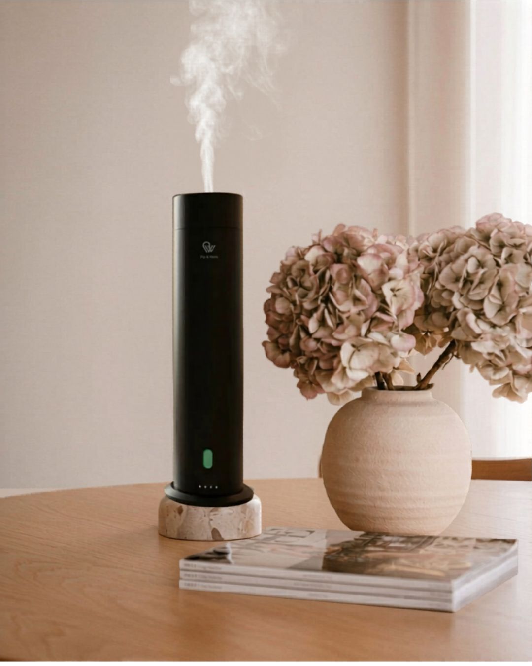 Pure One diffuser beside soft flowers in a calm interior