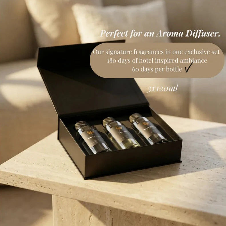Set of three diffuser bottles in a black box on a wooden surface with text about hotel-inspired ambiance.